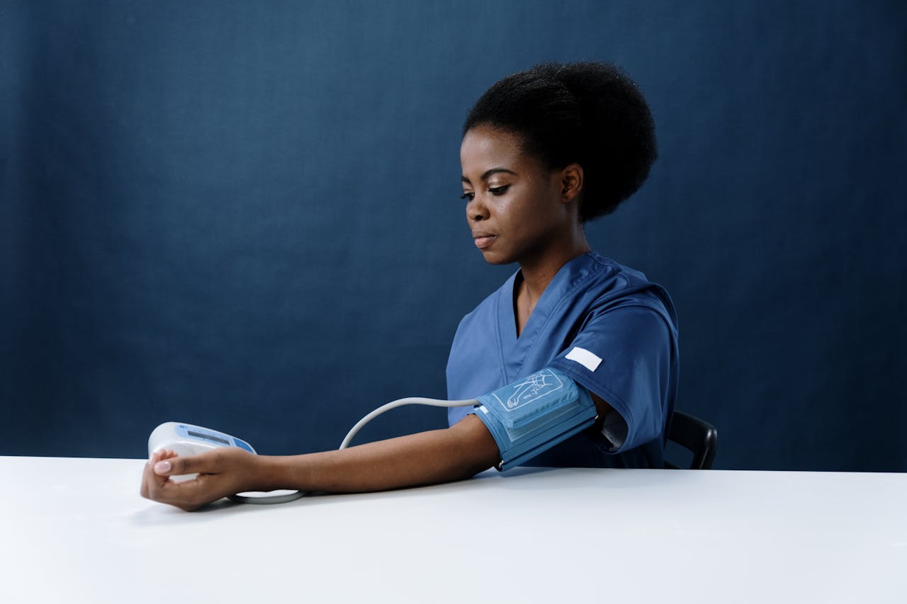 African American nurse measuring blood pressure, representing healthcare and medical practice.